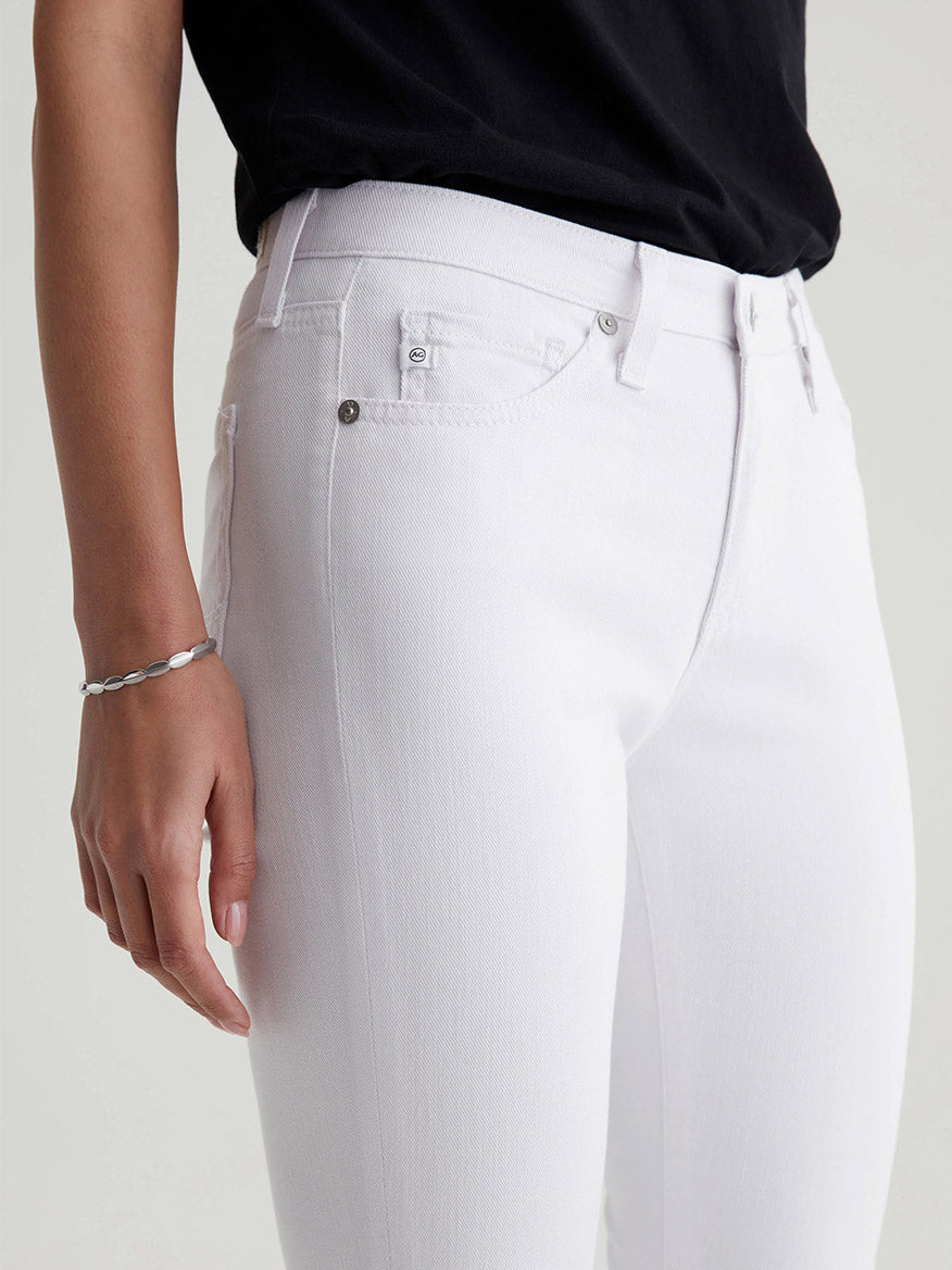 Person wearing AG Jeans Prima Cigarette Crop in White pants with a black top, focusing on the pocket detail.