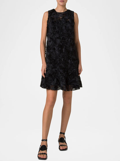 On a plain white background, a person wears the elegant Akris Punto Sleeveless 3D Carnation Knee Length Dress in black, paired with black sandals.