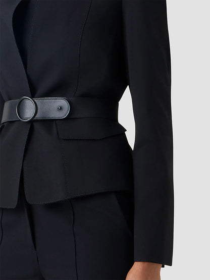 Model wears the Akris Punto Belted Jacket in Black with a stand collar, wide removable belt, and matching black pants, shown neck to mid-thigh against a plain light background.