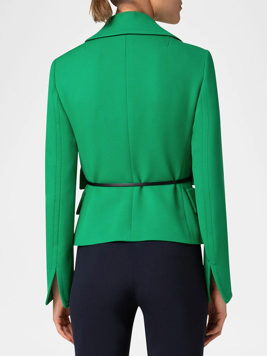 A person is seen from behind wearing the Akris Punto Fitted Belted Tricotine Jacket in sea green/navy, crafted from wool tricotine and cinched with a black belt, against a plain background.