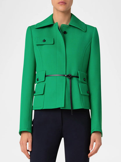 A person wearing an Akris Punto Fitted Belted Tricotine Jacket in sea green/navy, paired with black pants.