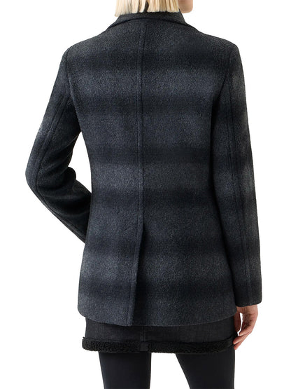 Person wearing an Akris Punto Blurred Check Wool Pea Coat in Charcoal/Black, viewed from the back, paired with a black skirt and dark pants.