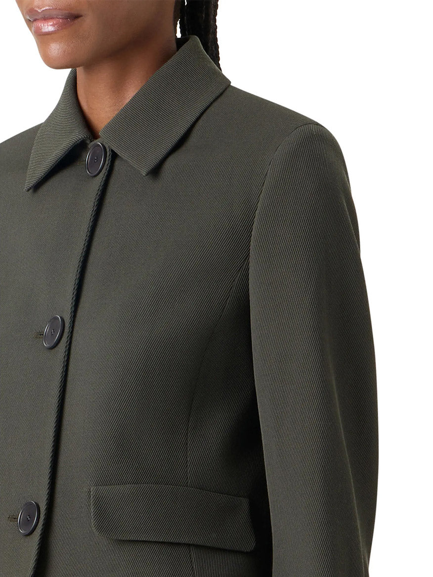 Close-up of the Akris Punto Boxy Wool Tricotine Jacket in Olive, featuring black buttons, decorative pocket flaps, and a collared button-up design, shown from the shoulders to mid-torso.