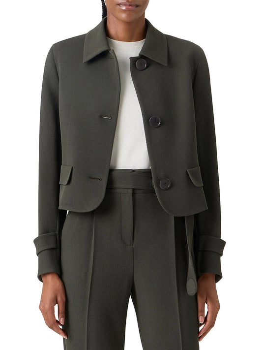 A person wears the Akris Punto Boxy Wool Tricotine Jacket in Olive, featuring decorative pocket flaps and large buttons, paired with matching high-waisted trousers and a white top.