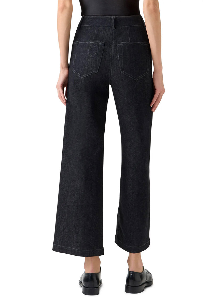 Person wearing Akris Punto Caia High-Rise Straight Leg in Black Denim, paired with a black top and black shoes, shown from the back against a white background.