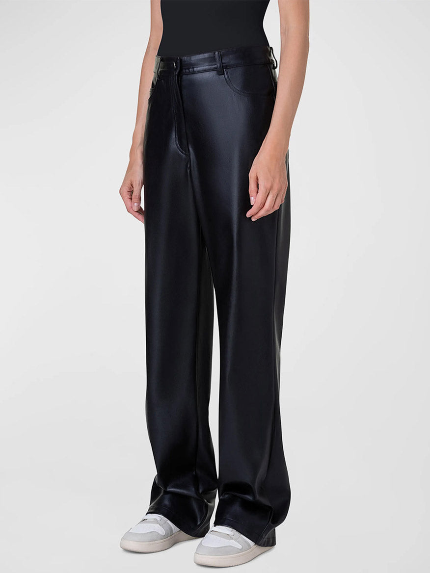 A woman wearing the Akris Punto Carrie Faux Leather Straight Leg Pant in Black and a white t - shirt.