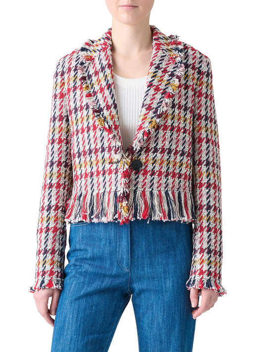 A person wearing the Akris Punto Houndstooth Tweed Fringe Trim Blazer in Cream Multi over a white top and blue jeans.