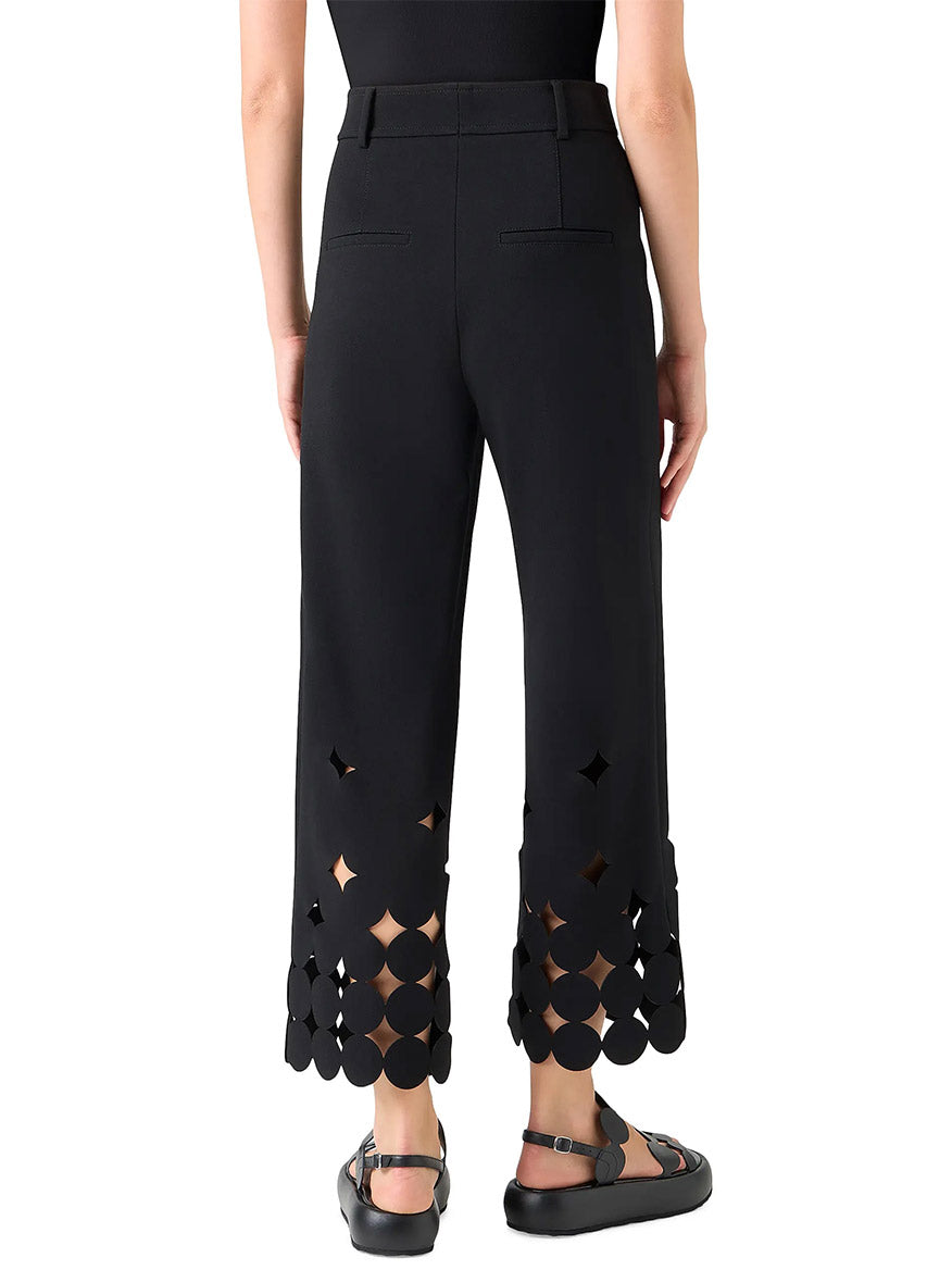 Model shown from the back wearing the Akris Punto Chieko Dropping Dot Cut Out Ankle Pant in Black, styled with a black top and flat sandals.