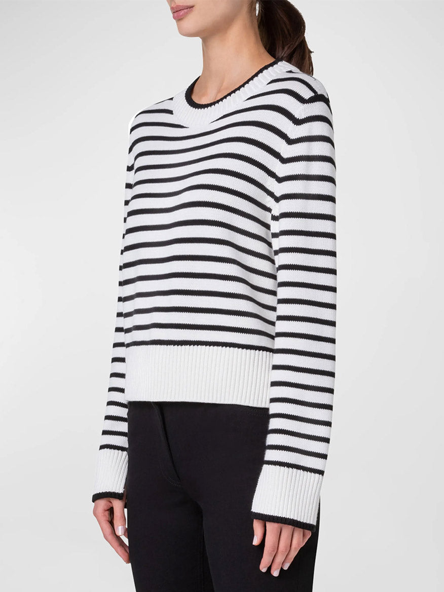 A person wearing an Akris Punto Chunky Cotton Stripe Sweater in Cream/Black with black pants stands against a plain background.