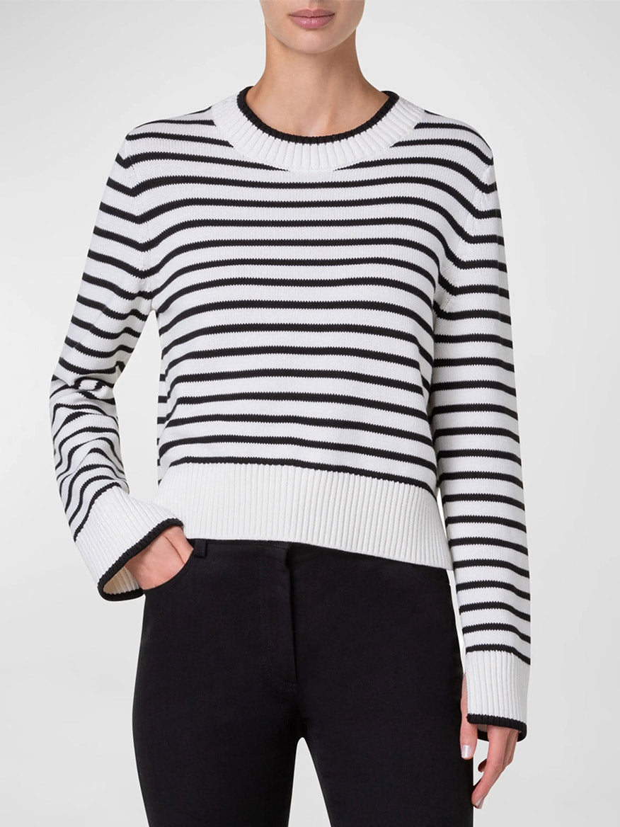 Person wearing an Akris Punto Chunky Cotton Stripe Sweater in Cream/Black and black pants, with one hand in pocket.