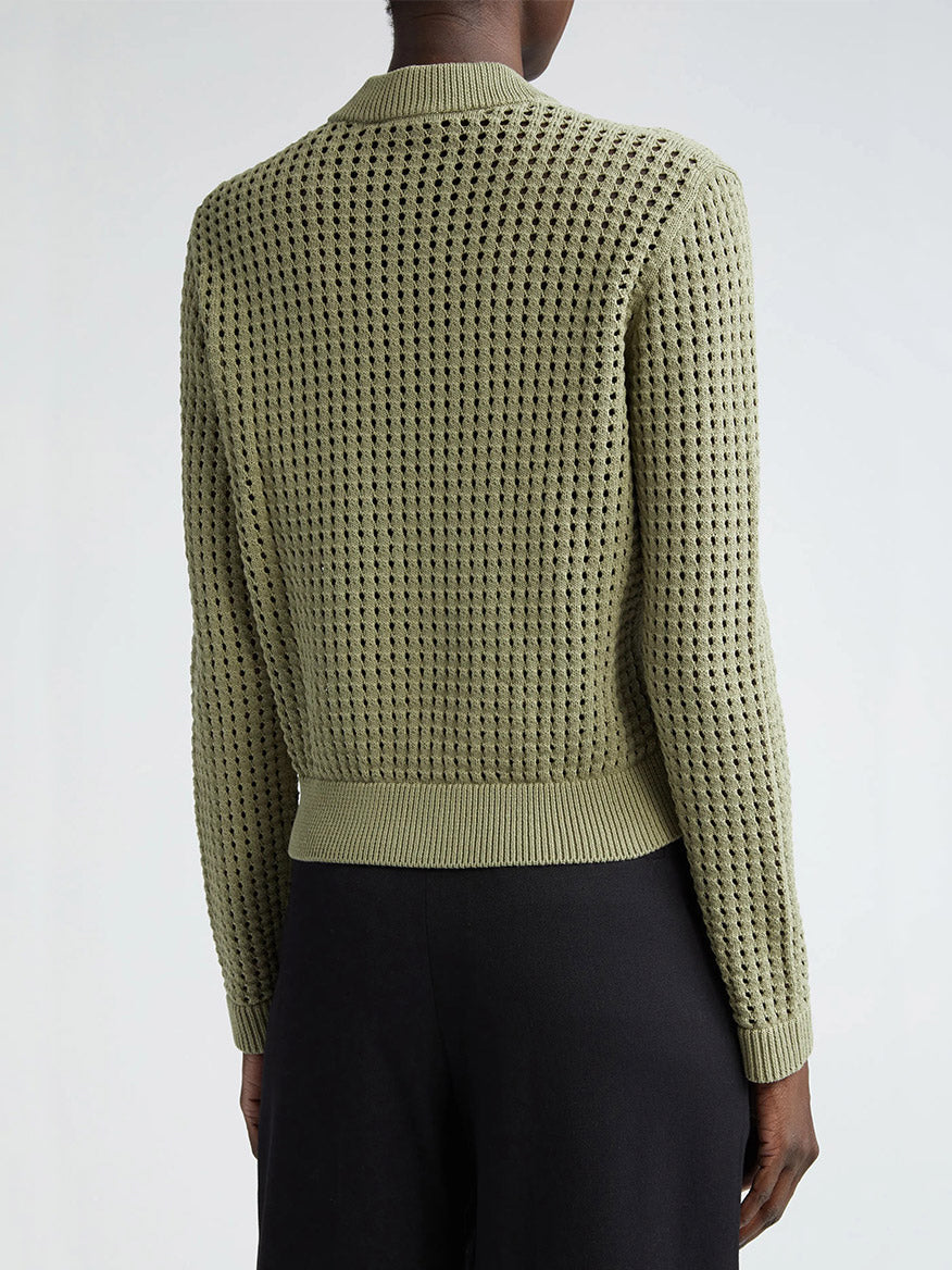 The back view of a woman wearing an Akris Punto Chunky Mesh Bomber Cardigan in Sage.