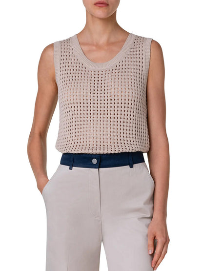 A woman wearing an Akris Punto Chunky Mesh Scoop Neck Tank in Cashew color with blue pants.