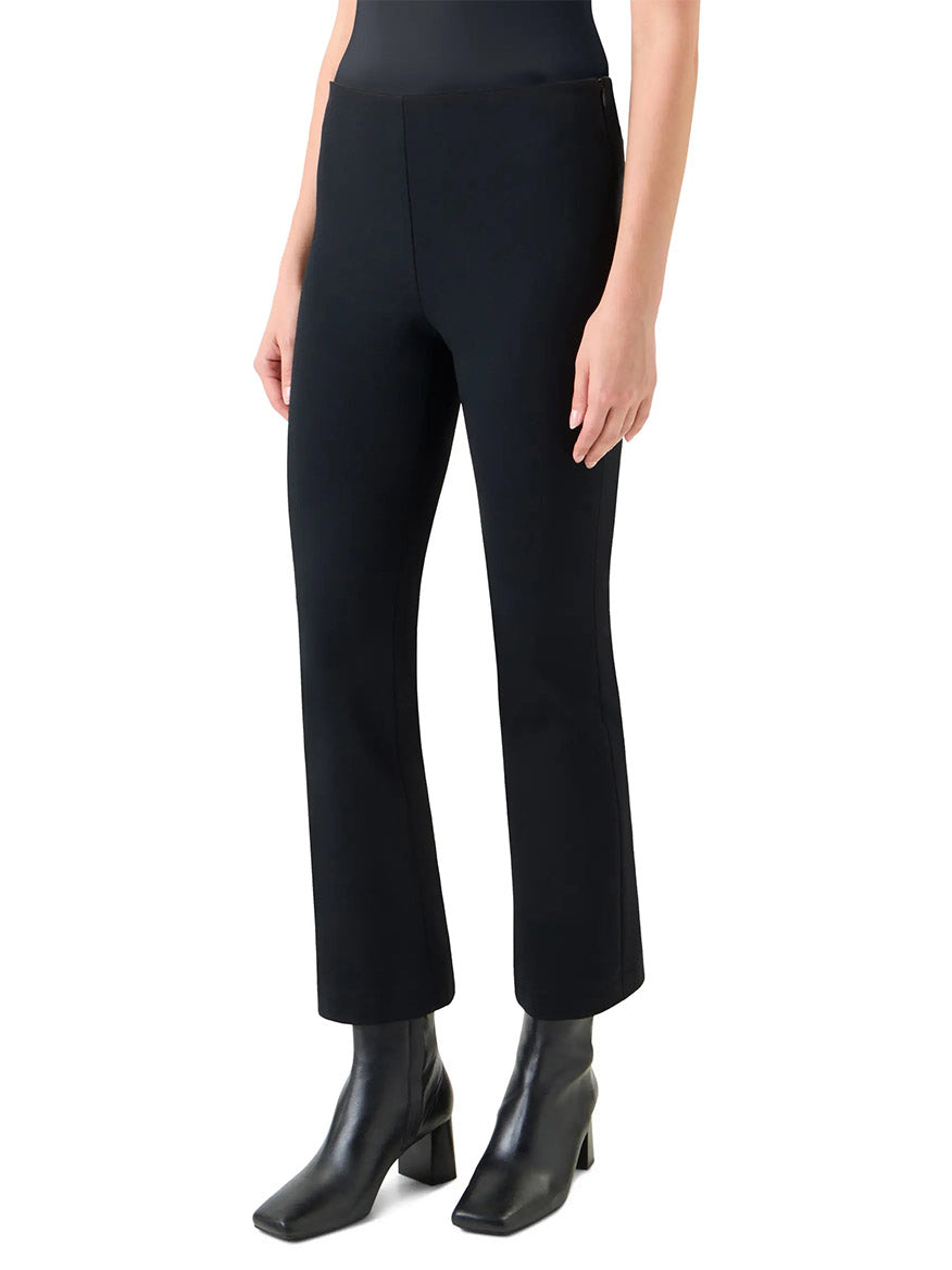 A person wears Akris Punto Elements Cindy Cropped Bootcut Pant in black with black ankle boots, standing against a white background.