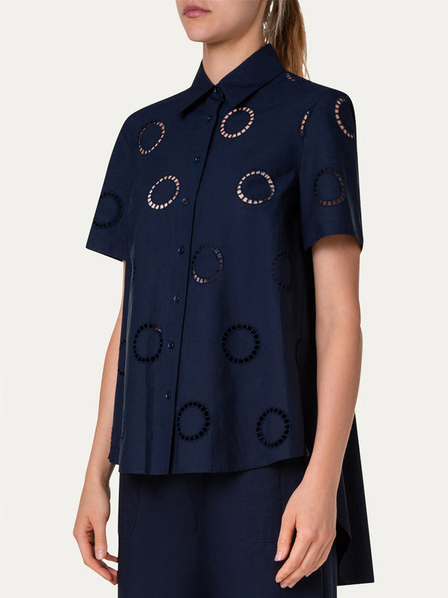 A woman wearing a blue cotton popeline blouse with circle eyelet embroidery by Akris Punto Circle Eyelet Embroidery Short Sleeve Blouse in Navy.