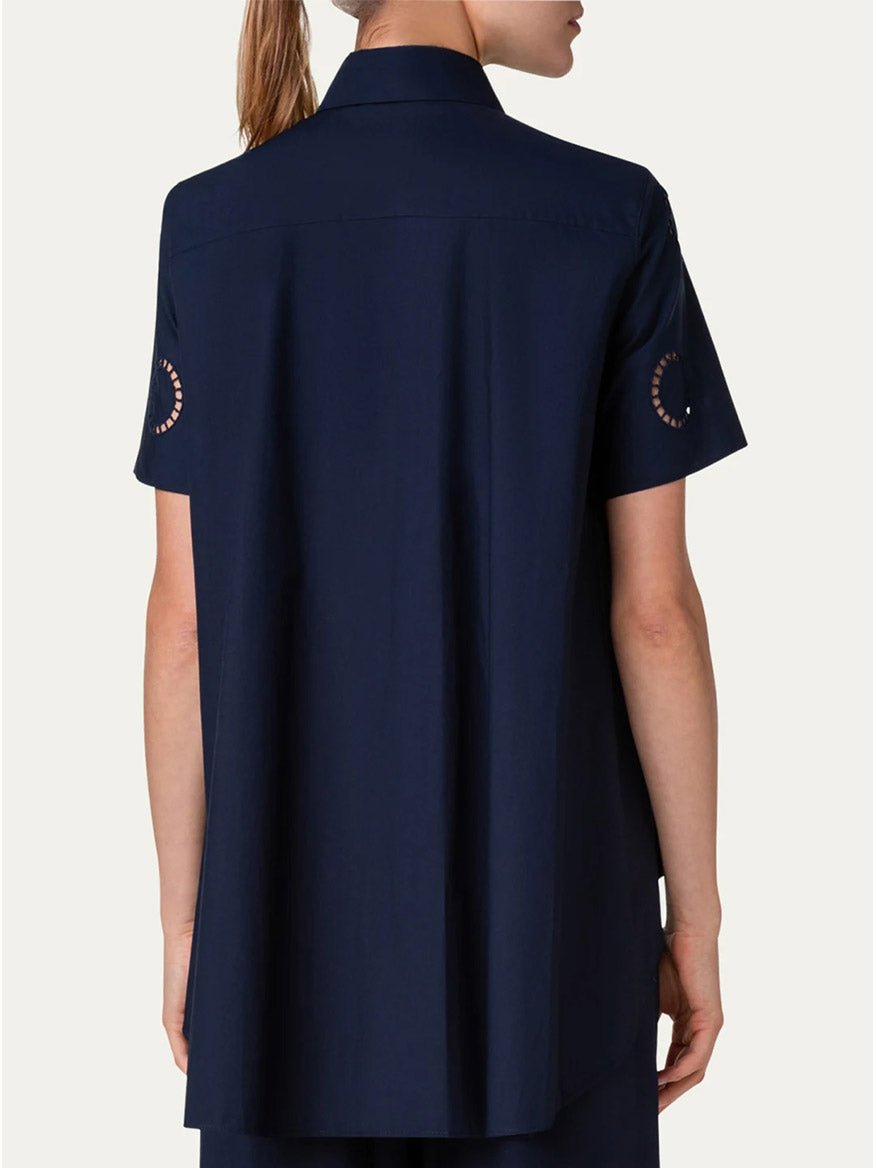 The back view of a woman wearing a navy Akris Punto Circle Eyelet Embroidery Short Sleeve Blouse and pants.