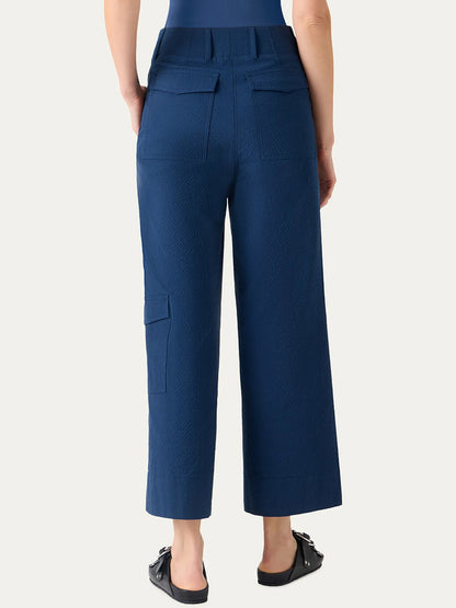 Person wearing Akris Punto Cliff Seersucker Cargo Pants in dark blue, featuring a high-waisted, wide-leg cargo style with back and side pockets, viewed from behind.
