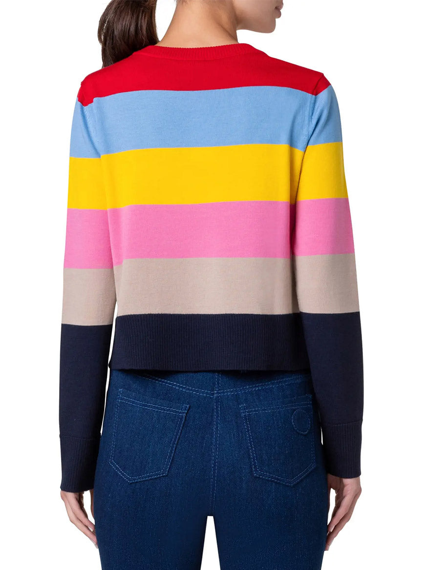 A person wearing an Akris Punto Colorblock Stripe Crewneck Sweater in Multicolor and blue jeans is pictured from the back.