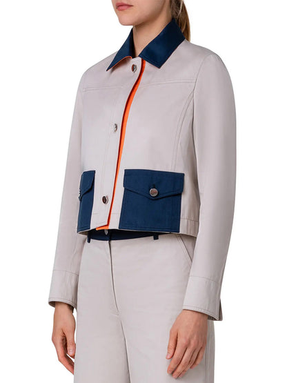 A woman wearing an Akris Punto Colorblock Crop Jean Jacket in Beige/Navy/Orange jacket and pants.
