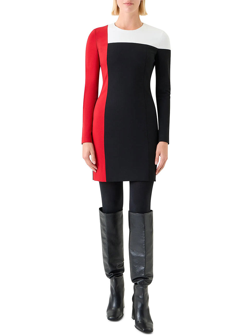 A woman wears the Akris Punto Signature Stretch Colorblock Shift Dress in Black/Cream/Vermillion, paired with black leggings and knee-high boots.