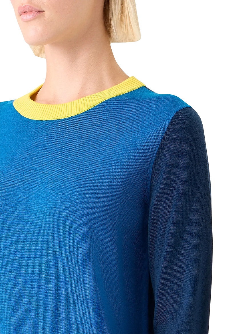 A person wears the Akris Punto Cool Wool Colorblock Crewneck Sweater in Cobalt Blue Multi, featuring dark blue sleeves and a yellow neckline, shown from the shoulders up against a white background.