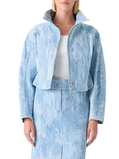 A woman wears the Akris Punto Washed Jacquard Denim Jacket in Sky Blue with a matching skirt and white top, standing against a plain background.