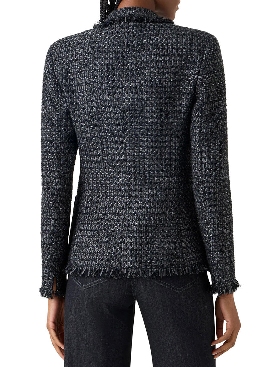 Person seen from the back wearing the Akris Punto Double-Breasted Fringed Tweed Jacket in Black/Stone with long sleeves and frayed edges, paired with dark jeans.