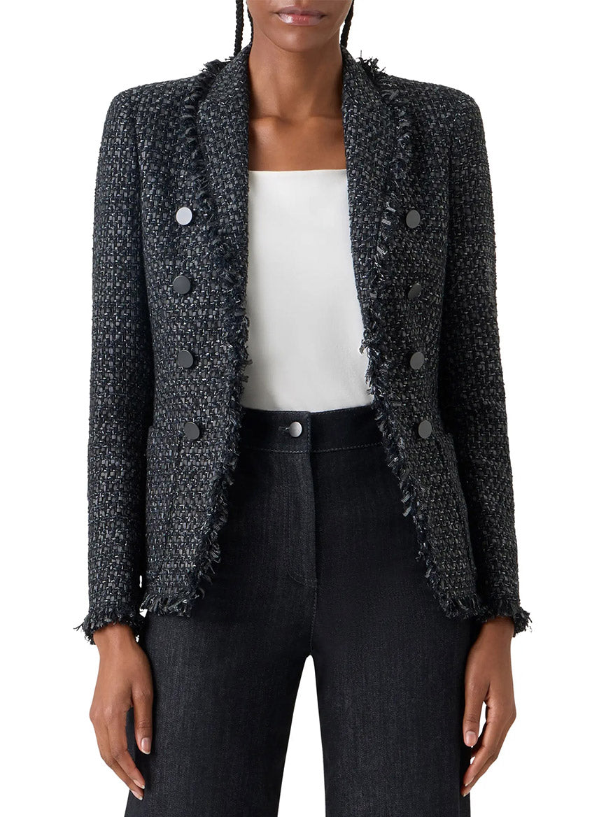 A woman wears the Akris Punto Double-Breasted Fringed Tweed Jacket in Black/Stone over a white top and black pants.