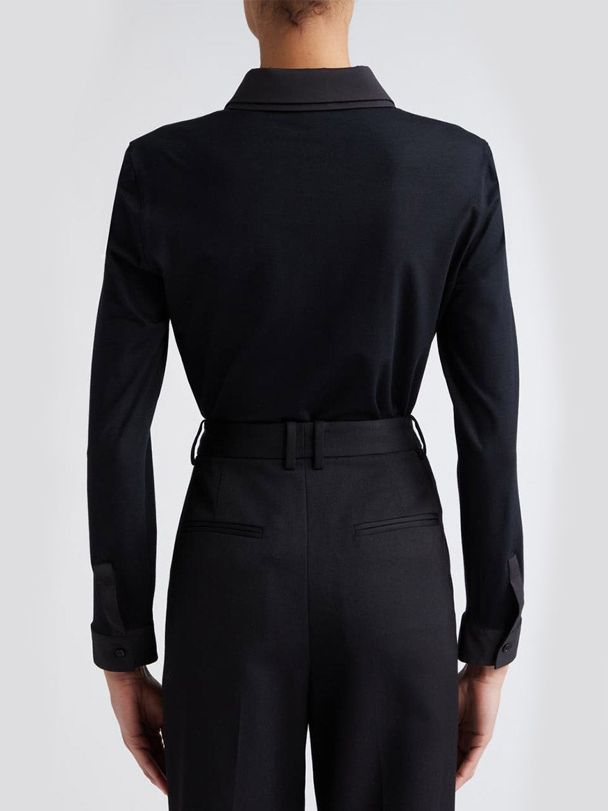 The back view of a woman wearing the Akris Punto Double Collar Jersey Back Shirt in black.