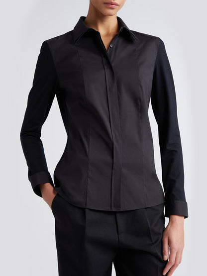 A woman wearing an Akris Punto Double Collar Jersey Back Shirt in Black and pants with a tailored fit.