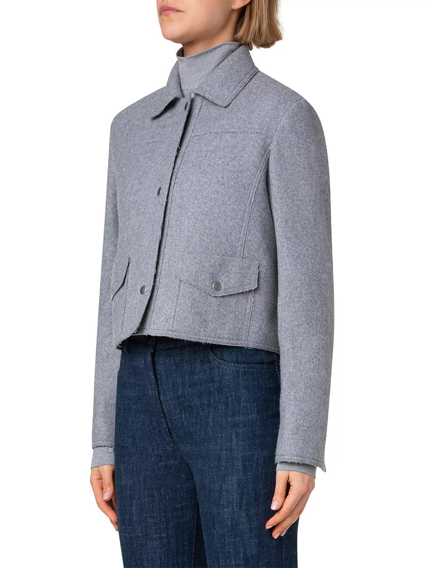 A person is wearing the Akris Punto Felted Wool Blend Short Patch Pocket Jacket in Grey over dark blue jeans, shown from the shoulders to the hips.