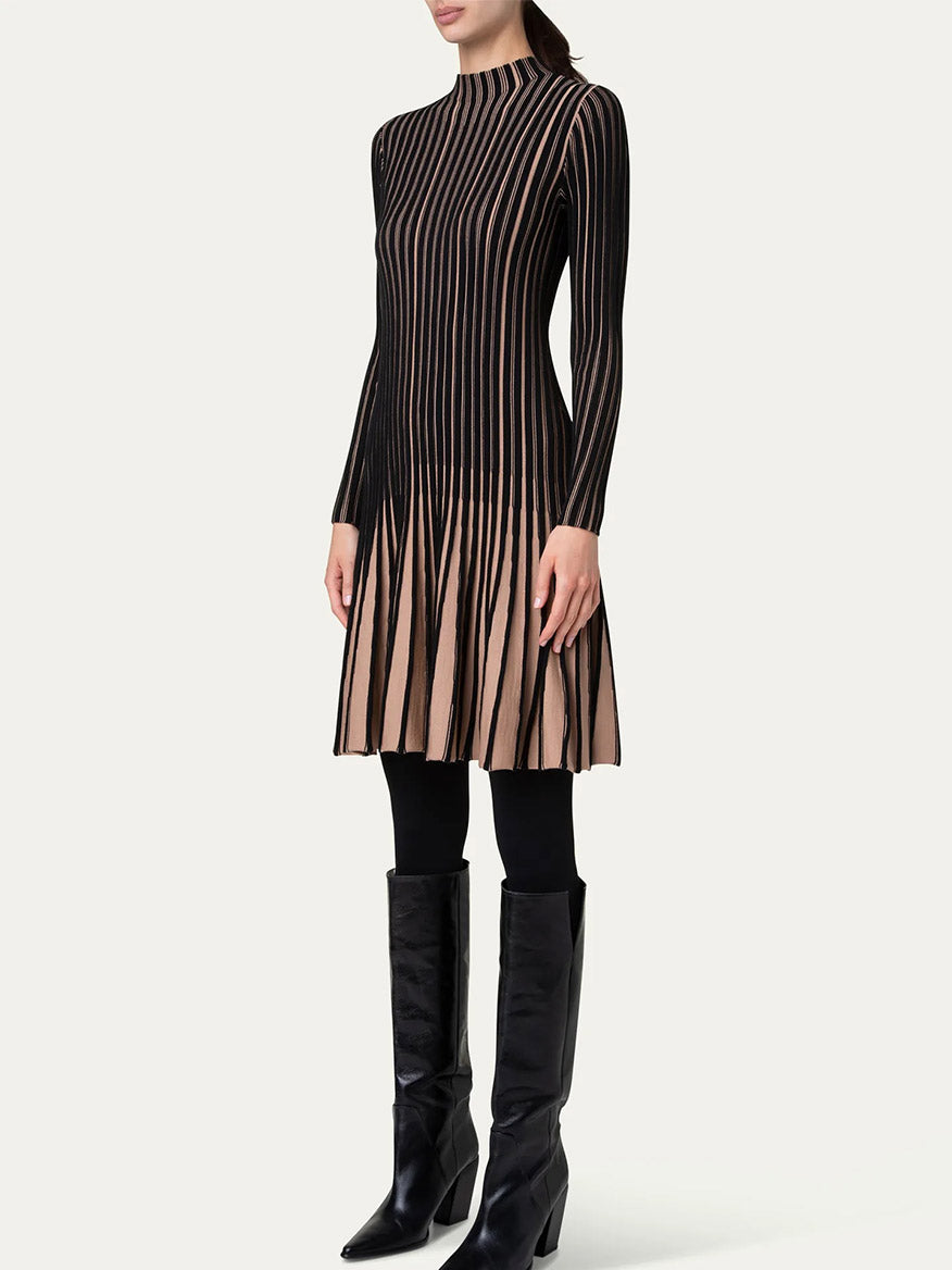 A person wearing the Akris Punto Ribbed Fit-and-Flare Dress in Black/Caramel stands with hands at their sides, paired with black leggings and tall black boots.