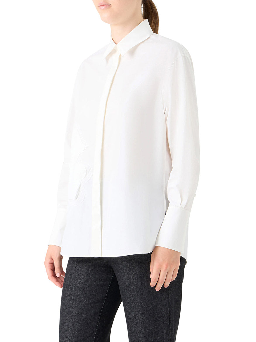 A woman wearing the Akris Punto XL Pop Dot Flower Applique Button Down Blouse in cream and black pants stands against a plain background.