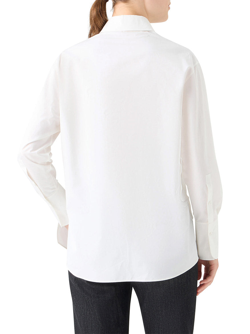 A person, shown from the back with hair tied back, wears the Akris Punto XL Pop Dot Flower Applique Button Down Blouse in Cream and dark pants.