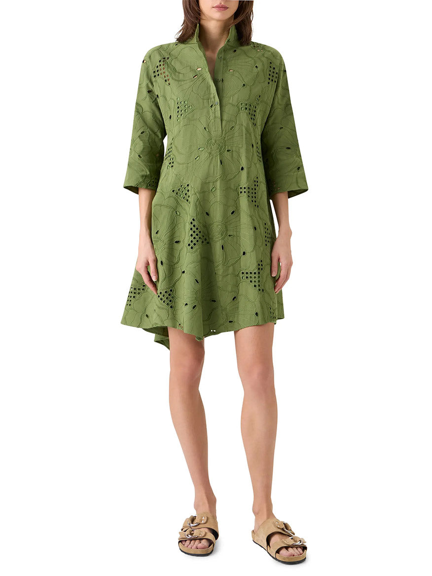 A woman wearing the Akris Punto Flower Eyelet Embroidered Handkerchief Dress in Green Tea, styled with tan slip-on sandals.