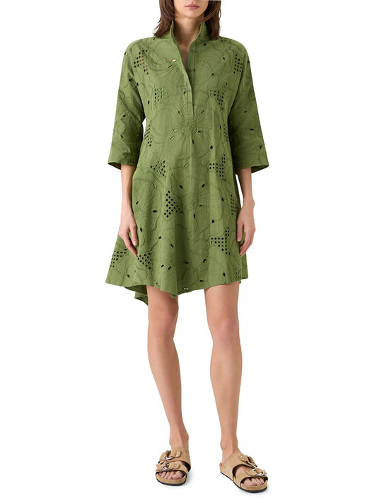 A woman wearing the Akris Punto Flower Eyelet Embroidered Handkerchief Dress in Green Tea, styled with tan slip-on sandals.