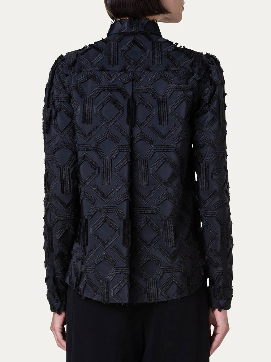 The back view of a woman wearing an Akris Punto Embroidered Fringe Puff Sleeve Blouse in Black.