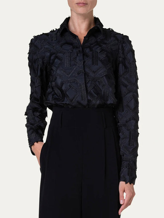 A woman wearing an Akris Punto Embroidered Fringe Puff Sleeve Blouse in Black, paired with wide leg pants.