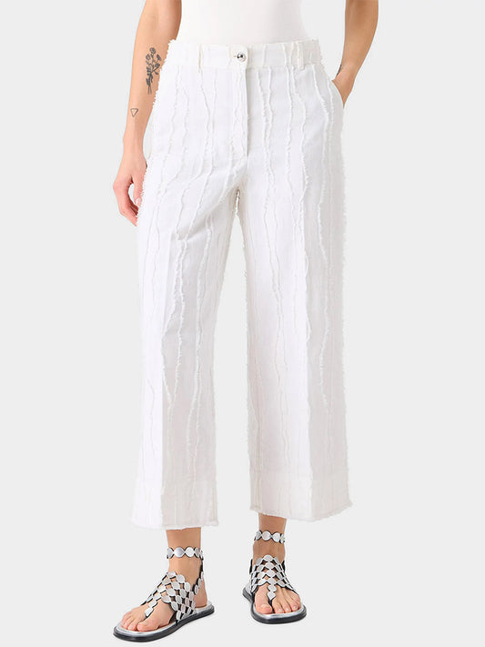 Wearing Akris Punto Chiara Fringed Wave Jacquard Wide Leg Pants in Cream with a matching top and black-and-white patterned sandals, this look highlights a sleek ankle silhouette against a light background.