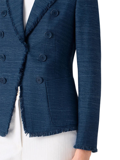 Model wears the Akris Punto Fringed Indian Silk Double-Breasted Jacket in Blue, paired with white pants; shown from shoulder to mid-thigh.