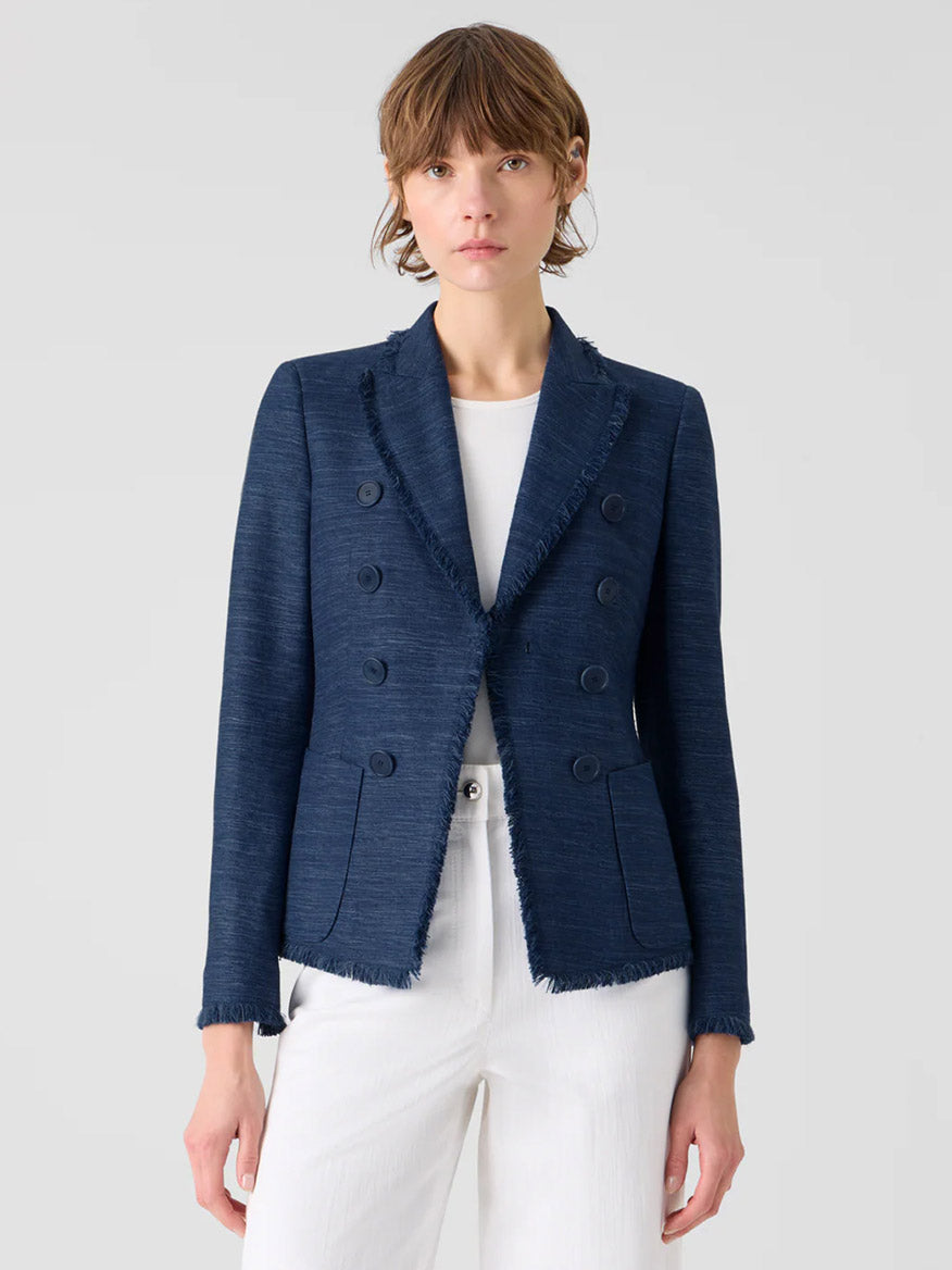 Person wearing the Akris Punto Fringed Indian Silk Double-Breasted Jacket in Blue over a white top and pants, standing against a plain light background.