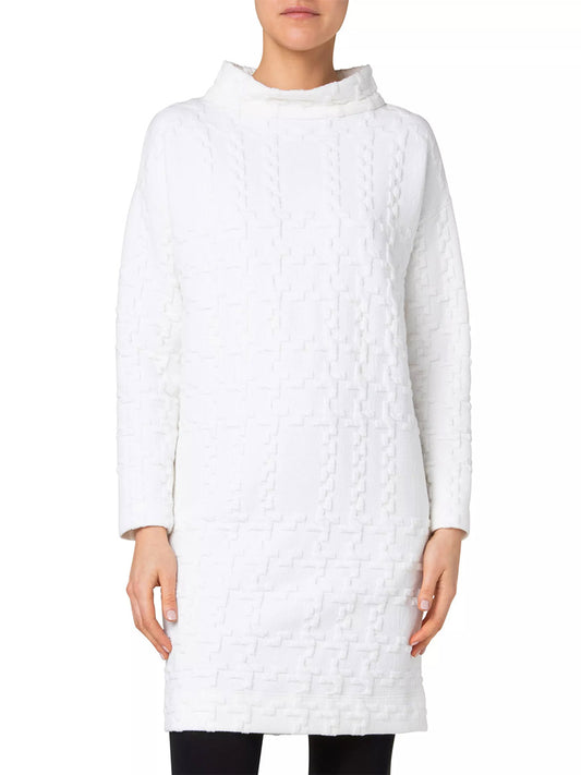 A person wearing the Akris Punto Glencheck 3D Jersey Oversize Dress in Cream exudes elegance in an ensemble that blends classic charm with modern sophistication. Shown from the front, this white textured long-sleeve dress features a subtle geometric pattern and a high neckline, capturing the essence of a glencheck 3D design perfectly.