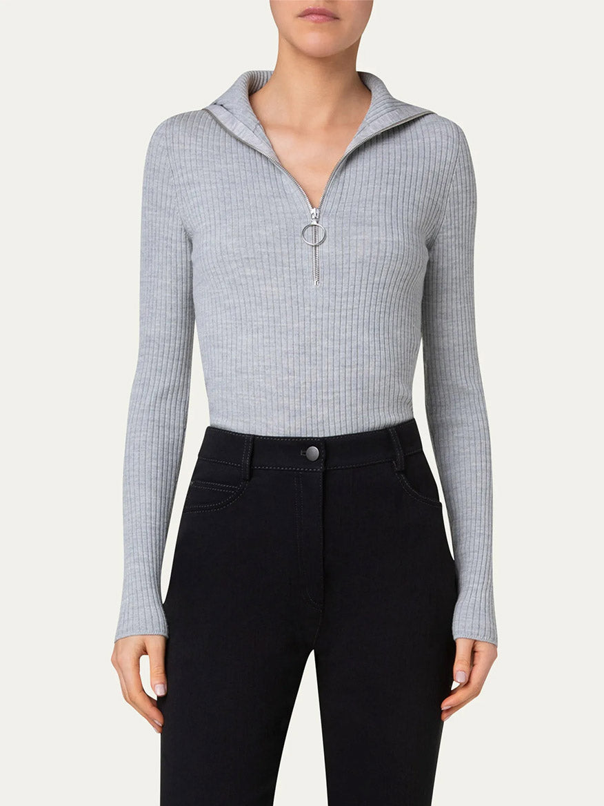 Person wearing an Akris Punto Half Zip Ribbed Polo Sweater in Silver paired with dark high-waisted pants.