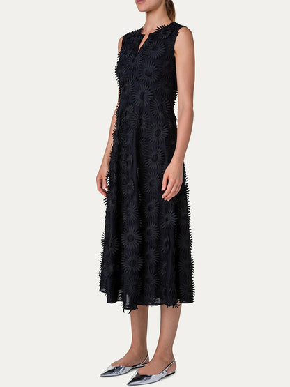 Woman standing side-on wearing a sleeveless Akris Punto Hello Sunshine Embroidered Dress in Black with a floral pattern, paired with silver shoes.