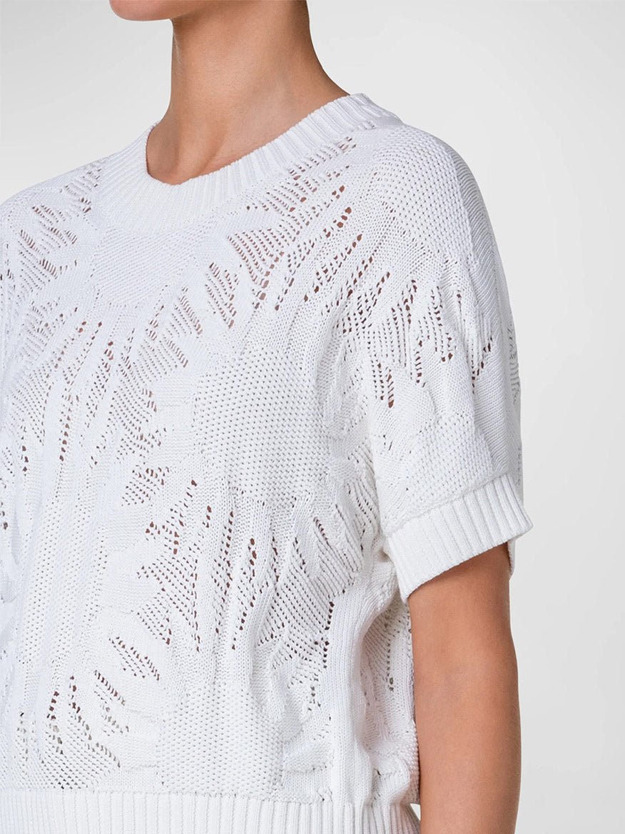 Close-up of a person wearing an Akris Punto Hello Sunshine Chunky Knit Pullover in Cream with a patterned design.