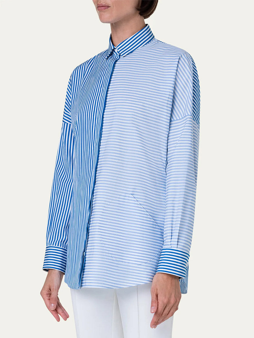 A woman wearing a blue and white striped shirt, featuring the Akris Punto Kodak Stripe Blouse in Ink/Sky.