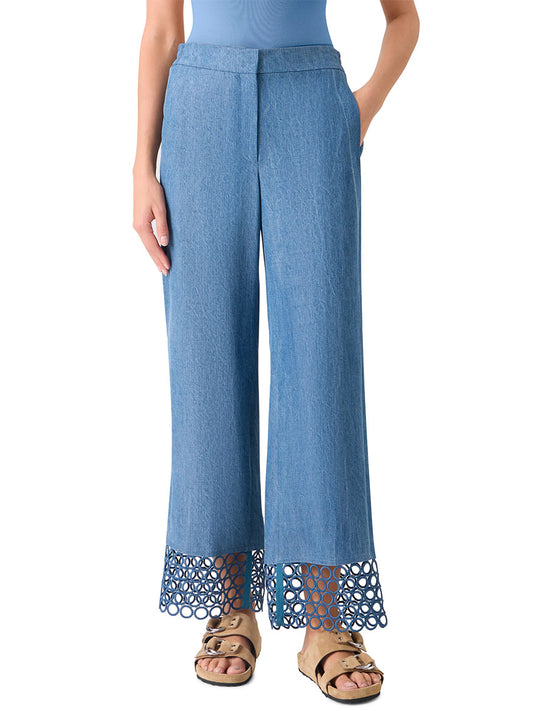 A woman wears Akris Punto Marlon Washed Denim Circle Lace Pants in medium blue, paired with a matching top and tan sandals.