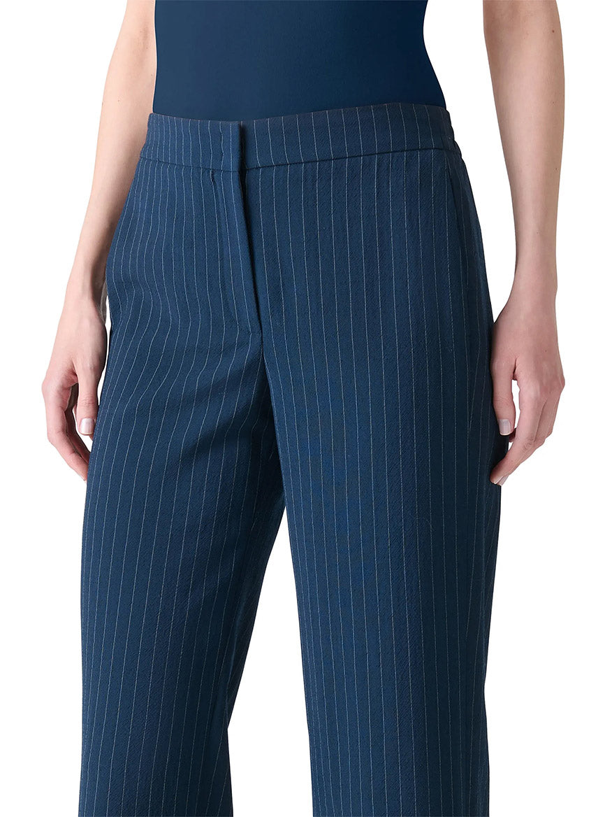 Model wearing Akris Punto Marlon Pinstripe Wide Leg Pant in Navy/Cream, crafted from a luxurious virgin wool blend, shown from waist to mid-thigh.