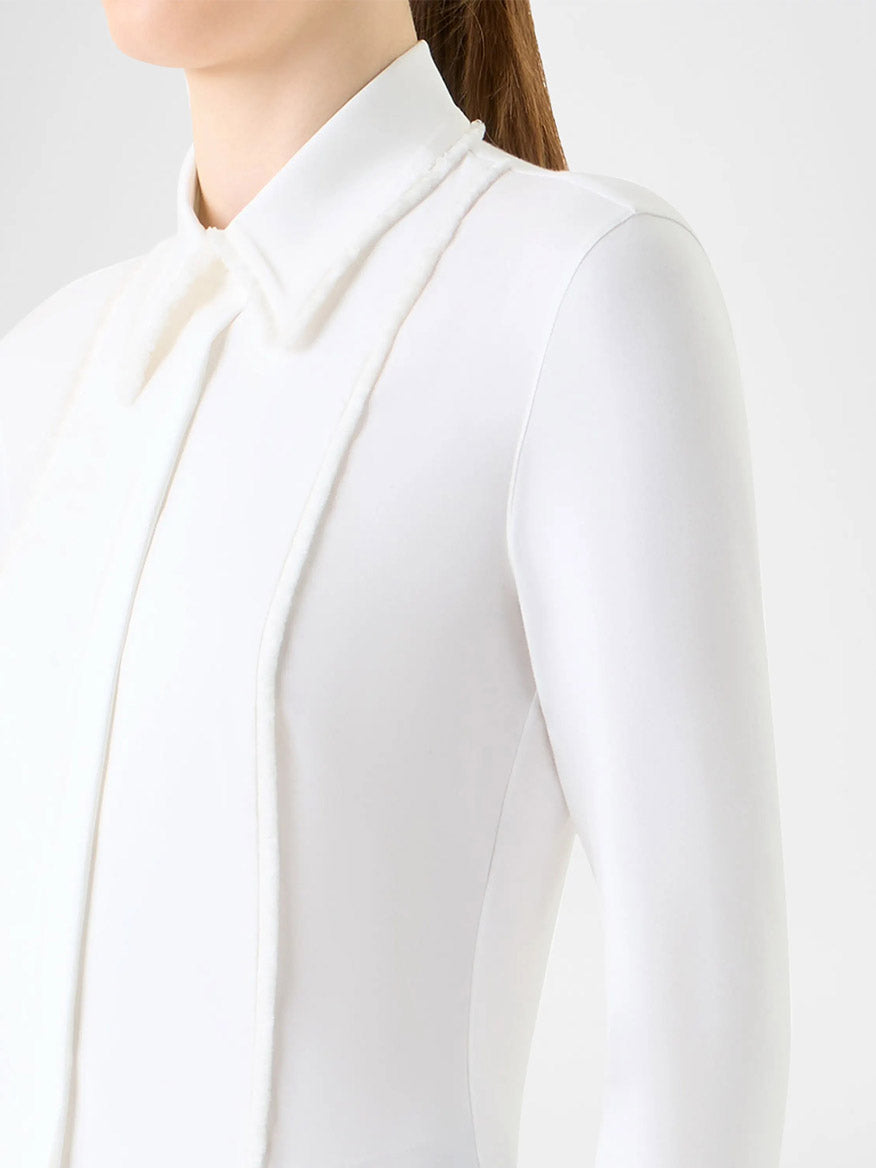 A person wearing the Akris Punto Mixed Media Fringed Button-Down Blouse in Cream, shown from the shoulders up against a plain light background.