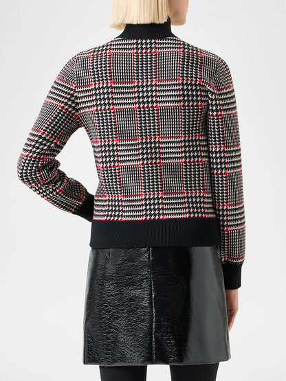 A person with blonde hair is shown from the back, wearing the Akris Punto Mock Neck Plaid Cardigan in Black/Cream/Vermillion and a shiny black skirt.
