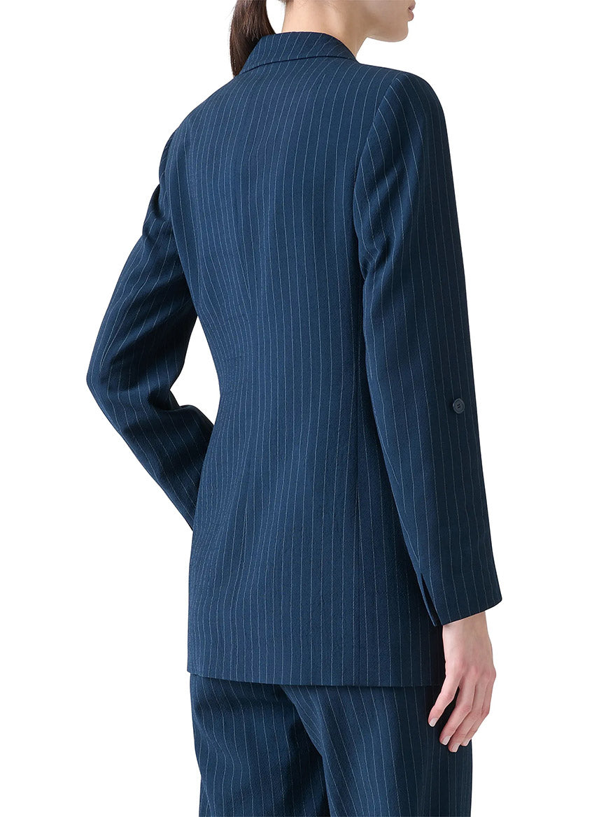 Someone stands facing away from the camera, showcasing the back and side profile of the Akris Punto Pinstripe Virgin Wool Jacket in Navy/Cream.